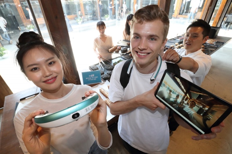 △KT 모델들이 목에 거는 넥밴드형 카메라 FITT 360을 착용하고, 360도 영상통화를 하고 있다/사진=KT