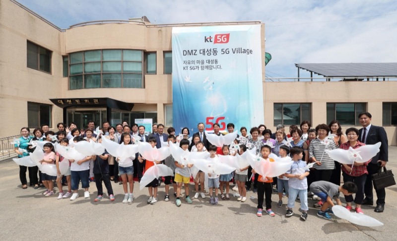 △황창규 KT 회장을 비롯한 KT임직원, 대성동마을 주민과 학생들이 기념촬영을 하고 있다/사진=KT