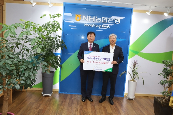 ▲권준학 NH농협은행 경기본부<사진 왼쪽>이 이민우 경기보증재단 이사장<사진 오른쪽)에게 기금을 전달하는 기념사진을 찍고 있다./사진제공=NH농협은행 경기본부.