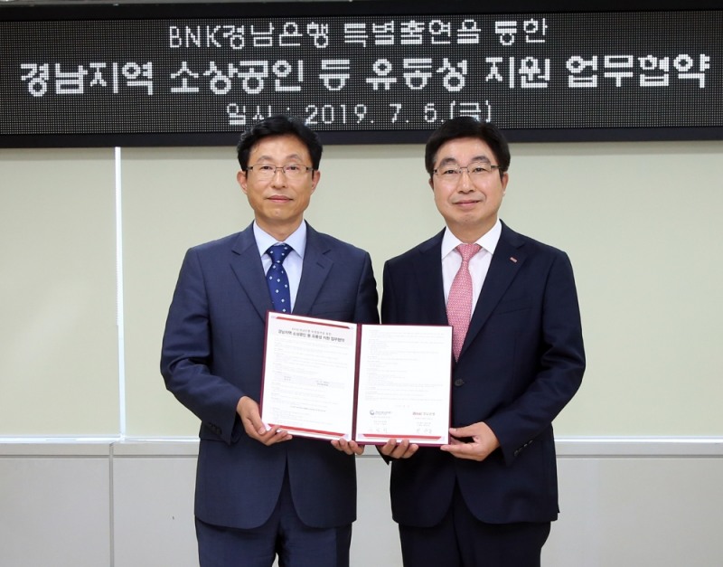 BNK경남은행 황윤철 은행장(사진 오른쪽)이 경남신용보증재단 구철회 이사장과 경남지역 소상공인 등 유동성 지원 업무 협약을 체결한 뒤 기념촬영하고 있다./사진=경남은행