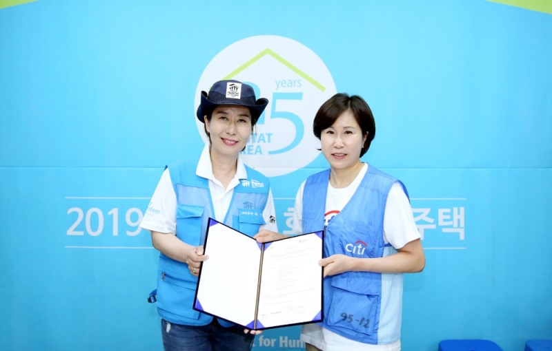 유명순 한국씨티은행 수석부행장(오른쪽)이 손미향 한국해비타트 사무총장(왼쪽)에게 협약서를 전달하고 있다./사진=한국씨티은행
