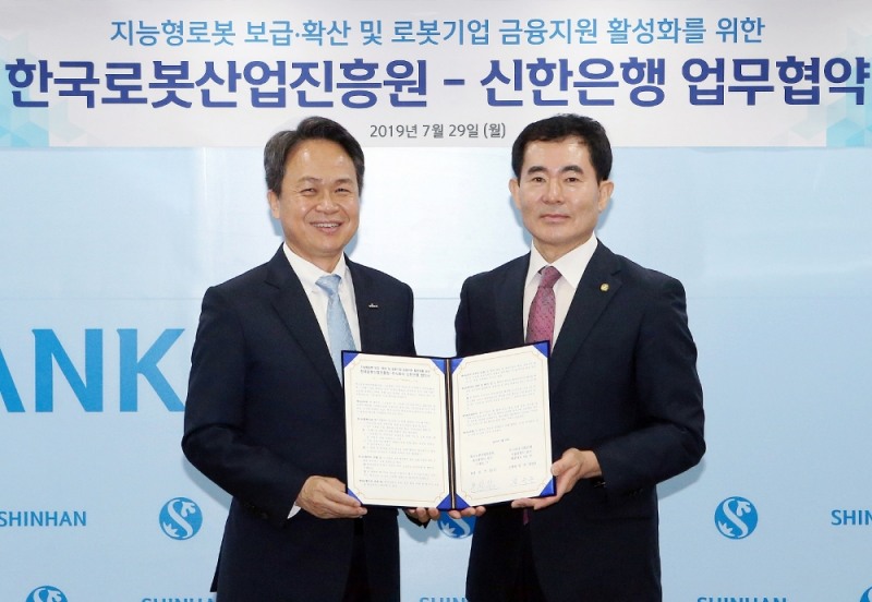 29일 서울시 중구 소재 신한은행 본점에서 한국로봇산업진흥원과 가진 ‘지능형로봇 보급·확산 및 로봇기업 금융지원 활성화를 위한 업무협약’에서 협약식을 마치고 진옥동 신한은행장(왼쪽)과 문전일 한국로봇산업진흥원장(오른쪽)이 기념촬영 하는 모습. / 사진= 신한은행