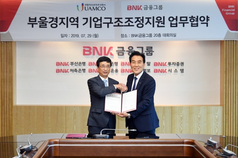 김지완 BNK금융 회장(오른쪽), 김석민 유암코 대표이사가 ‘부울경 지역 기업구조조정지원 업무협약’을 체결 후 기념촬영을 하고 있다./사진=BNK금융