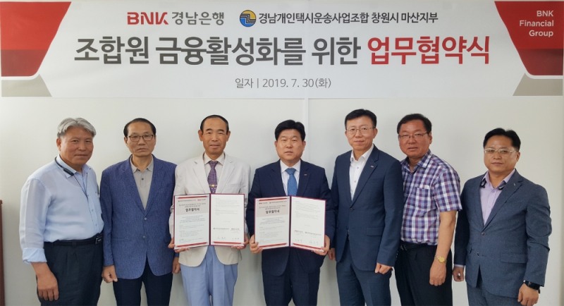 BNK경남은행 이창우 상무(사진 오른쪽 네번째)가 경남개인택시운송사업조합 창원시 마산지부 강신봉 지부장(사진 왼쪽 세번째)과 ‘금융 지원 업무 협약’을 체결한 뒤 기념촬영하고 있다./사진=경남은행