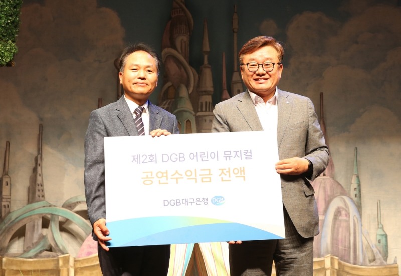 남재수 대구서문복지재단 관장(왼쪽) 임성훈 대구은행 상무가 공연수익금 전달 후 기념촬영을 하고 있다./사진=대구은행