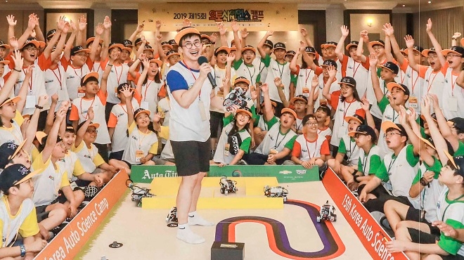 오토사이언스 캠프 참가자들이 자율주행차 주행 원리에 대해 설명을 듣고 직접 코딩한 교육용 자율주행차로 경연을 펼치고 있다. (사진=한국지엠)