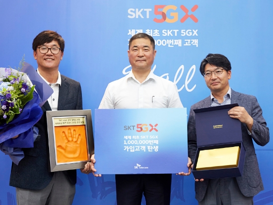 ▲김성수 SKT 영업본부장, 100만번째 고객 이상국 씨, 임봉호 SKT 부산마케팅본부장(왼쪽부터)이 핸드 프린팅과 경품을 들고 포즈를 취하고 있다. /사진=SKT