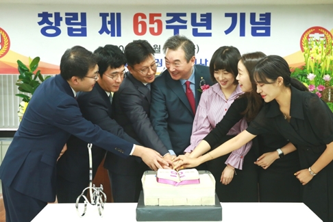 박현철 부국증권 대표이사 사장(가운데)이 창립 65주년 기념행사에서 직원들과 함께 케이크를 자르고 있다./사진=부국증권
