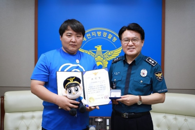 (왼쪽부터) 이진우 바로고 대전 중앙 허브(지사)소속 라이더, 황운하 대전지방경찰청장이 수여식 후 기념촬영을 하고 있다./사진=바로고