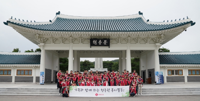 롯데건설 임직원 가족들이 현충문 앞에서 봉사활동 기념촬영을 하고 있다. /사진=롯데건설