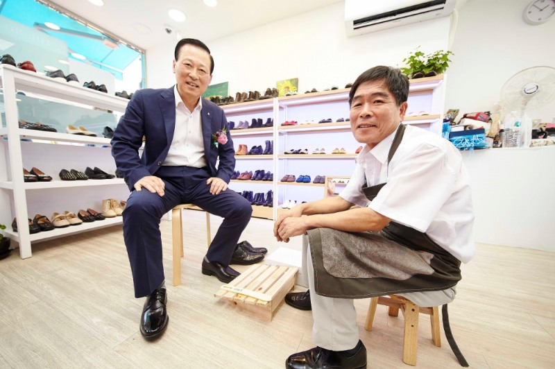 27일 염천교 수제화거리에 있는 수제화 판매점에서 김도진 기업은행장이(왼쪽) 수제화를 구입하고 고기황 염천교 수제화거리 상인회장과 기념촬영을 하고 있는 모습. / 사진= 기업은행