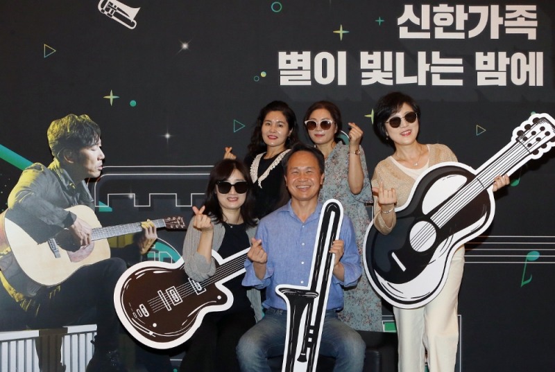 28일 서울시 동대문구 회기동 소재 경희대학교 평화의 전당에서 개최된 ‘신한가족 별이 빛나는 밤에 콘서트’에서 진옥동 신한은행장(사진 가운데)이 직원 가족들과 포토존에서 기념촬영 하는 모습. / 사진= 신한은행