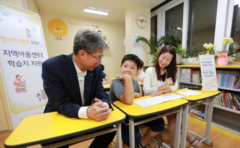 허인 KB국민은행장(왼쪽 첫 번째)이 지난 2일 광명시 힘찬키움지역아동센터를 방문해 '지역아동센터 학습지 지원 사업' 진행 현황과 아이들의 학습여건을 살펴보고 있다.   / 사진= KB국민은행