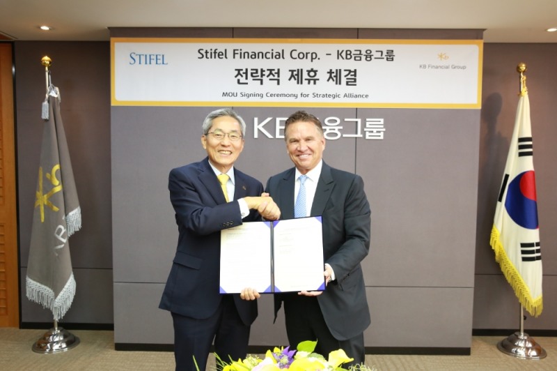 21일 서울 여의도 KB국민은행 본점에서 윤종규 KB금융그룹 회장(좌측), 론 크루셰프스키 스티펠 파이낸셜 회장(우측)이 전략적 제휴를 위한 양해각서(MOU) 체결 후 기념사진을 촬영하고 있다. / 사진= KB금융지주