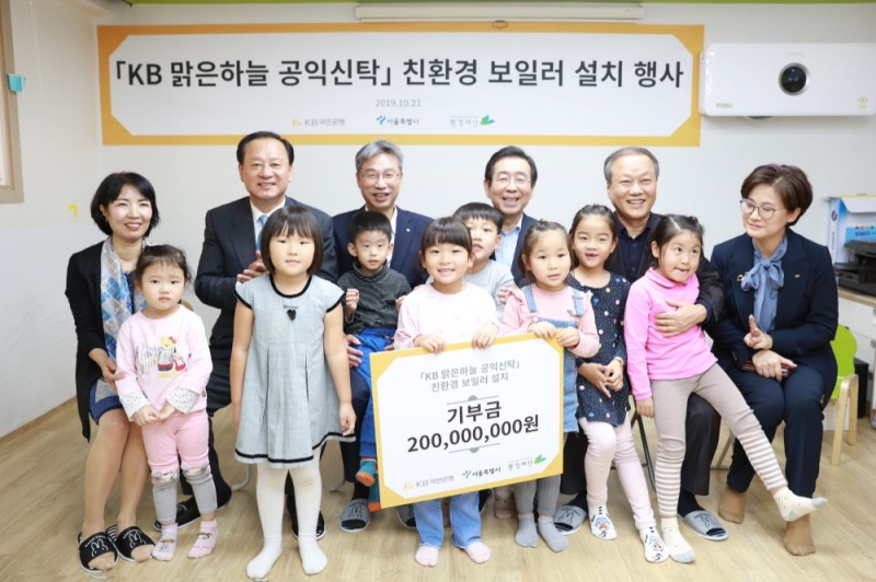 21일 서울 마포구 신수 어린이집에서 열린 'KB 맑은하늘 공익신탁 친환경 보일러 설치 행사'에서 참석자들이 기념촬영을 하고 있다. (뒷줄 왼쪽에서 세번째부터) 허인 KB국민은행장, 박원순 서울시장, 최열 환경재단 이사장. / 사진= KB국민은행