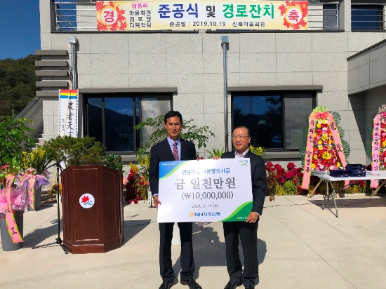 NH저축은행이 지난 19일 '또 하나의 마을' 결연을 맺고 있는 강원도 홍천군 내촌면 단풍마을의 마을회관 준공식에 참석해 발전기금을 전달하고 수확기를 맞아 부족한 일손을 돕기 위한 봉사활동을 실시했다. NH저축은행 김건영 대표이사(사진 오른쪽)이 마을발전기금을 전달하고 있다. / 사진 = NH농협금융