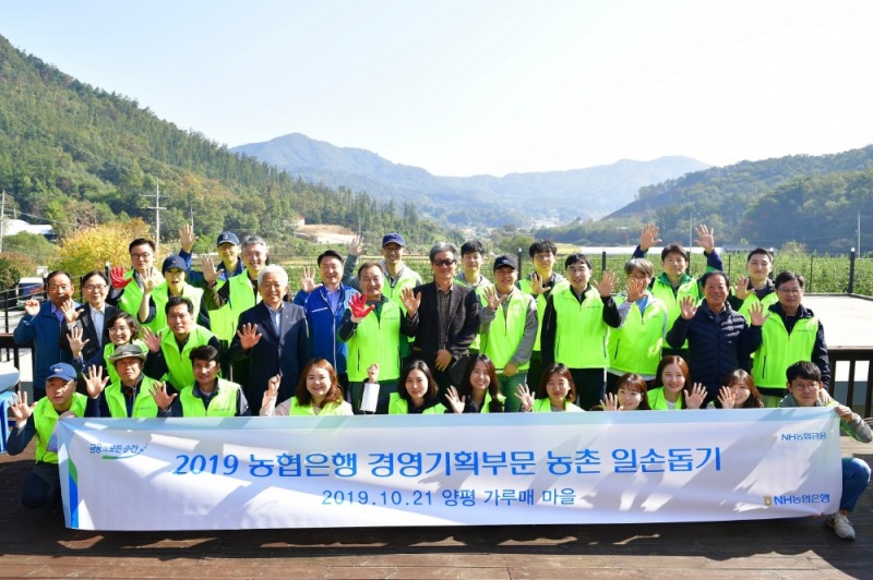 21일 이창호 수석부행장(두번째 줄 왼쪽부터 네 번째)과 경영기획부문 직원들이 경기도 양평 가루매마을에서 일손돕기 후 기념사진을 촬영하고 있다./사진=농협은행