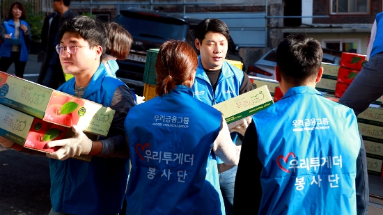 지난 24일 우리투게더 봉사단이 서울 남대문 쪽방촌에 전달하기 위한 사과박스를 나르고 있다. / 사진 = 우리카드