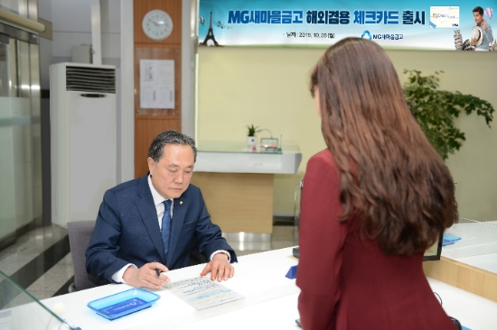 박차훈 새마을금고중앙회장(왼쪽)이 28일 새마을금고 한 영업점에서 해외겸용 체크카드 발급 신청서를 작성하고 있다. / 사진 = 새마을금고중앙회