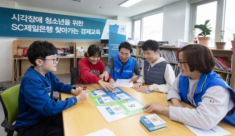 지난 5일 서울 강북구 한빛맹학교에서 열린 ‘시각장애 청소년을 위한 찾아가는 경제교육’ 프로그램에서 초등학생들이 SC제일은행 직원 봉사자들과 함께 금융진로 맞추기 보드게임을 하고 있다./사진=SC제일은행