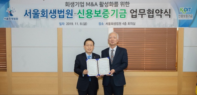 윤대희 신용보증기금 이사장(왼쪽)이 정형식 서울회생법원장(오른쪽)과 함께 8일 서울회생법원에서 열린 '회생기업 M&A 활성화를 위한 업무협약'에서 기념촬영을 하고 있다./사진=신용보증기금