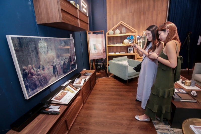 △삼성전자 싱가포르 체험공간에 방문한 관람객들이 더 프레임 TV 65형을 체험하고 있다/사진=삼성전자