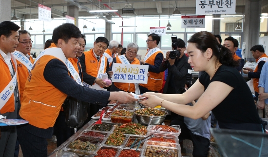 김윤식 신협중앙회 회장이 거제 시장 상인에게 반찬을 사고 있다. / 사진 = 신협중앙회