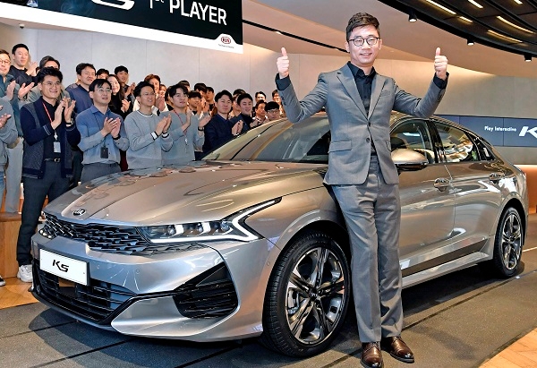 16일 ‘3세대 K5’ 퍼스트플레이어로 선정된 김동귀씨가 차량 앞에서 기념촬영을 하고 있다. (사진=기아차)
