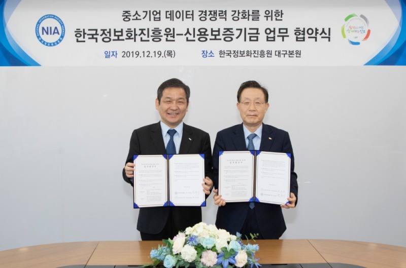 윤대희 신용보증기금 이사장(오른쪽)이 문용식 한국정보화진흥원장(왼쪽)과 함께 19일 대구 동구 한국정보화진흥원 본원에서 열린 ‘중소기업 데이터 경쟁력 강화를 위한 업무협약’에서 기념촬영을 하고 있다./사진=신용보증기금