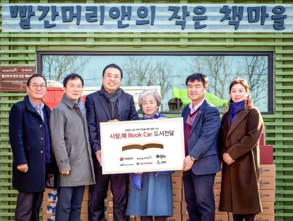 비씨카드가 지난해 산불로 인해 전소되었다가 다시 개관하는 강원도 고성군 작은도서관 ‘빨간머리 앤의 작은 책마을’에 서적과 도서관 운영 물품을 기증했다고 15일 밝혔다. 지난 14일 도서관에서 김영선 비씨카드 홍보팀장(왼쪽에서 세번째), 박영숙 관장(왼쪽에서 네번째), 김창래 고성군 관광문화과장(오른쪽에서 두번째) 등 주요 관계자들이 도서 전달식을 가진 후 기념사진을 촬영하고 있다. / 사진 = 비씨카드