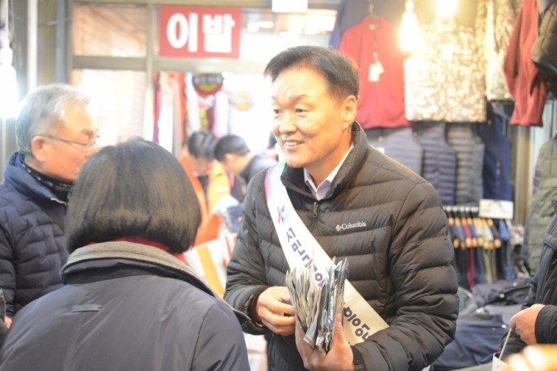 이계문 서민금융진흥원장 겸 신용회복위원장이 15일 서울 연서시장에서 전통시장 상인에게 홍보물품을 나누어주고 있다./사진=서민금융진흥원