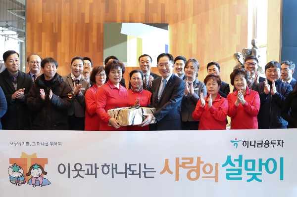 ▲이진국 하나금융투자 사장(가운데)과 하나금융투자 건물 근로자, 하나금융투자 임직원이 '이웃과 하나되는 사랑의 설 맞이' 행사를 기념해 함께 사진촬영을 하고 있다./ 사진=하나금융투자