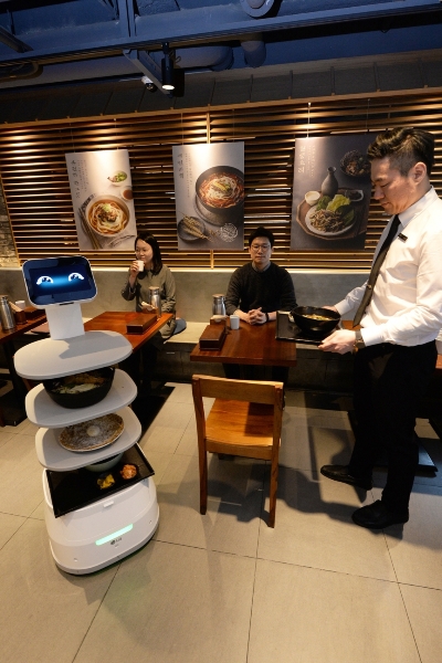 제일제면소 서울역사점에 방문한 고객들이 LG 클로이 서브봇을 체험하고 있다/사진=LG전자 