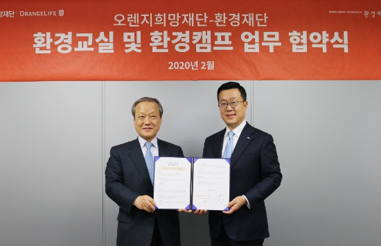 오렌지희망재단 정문국 이사장(오른쪽)과 환경재단 최열 이사장이 조인식을 마친 후 협약서를 들어보이고 있다. / 사진 = 오렌지라이프