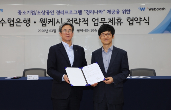 △ 이동빈 Sh수협은행 은행장(왼쪽)과 윤완수 웹케시 윤완수 부회장(오른쪽)이 업무협약서에 서명하고 기념촬영을 하고 있다. /사진=Sh수협은행