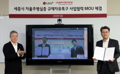 강종오 LG유플러스 모빌리티사업담당 상무(사진 우측)와 김응수 켐트로닉스 자율주행사업부문장 전무(TV속 좌측)가 원격회의를 통해 세종시 자율주행 실증 사업에 대한 업무협약을 맺는 모습. 제공=LG유플러스