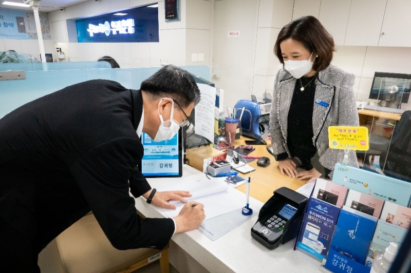 은성수 금융위원장이 1일 시중은행 지점에서 코로나19 관련 금융지원방안의 원활한 이행을 위해 현장지원을 하고 있다. 은성수 위원장이 서울 중구 우리은행 남대문시장지점에서 공문에 서명을 하고 있다. / 사진= 금융위원회(2020.04.01)