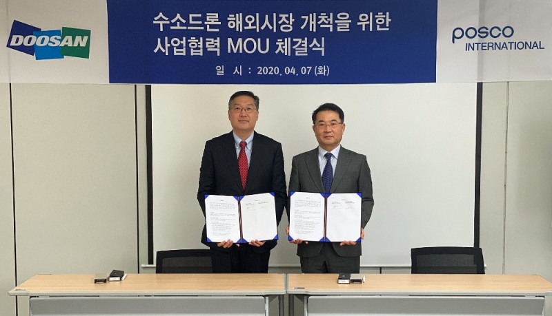 이두순 DMI 대표(왼쪽)와 유재진 포스코인터내셔널 자동차사업실장이 협약서를 들고 기념촬영을 하고 있다/사진=두산모빌리티이노베이션