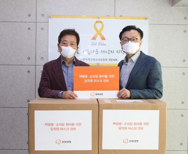 김영식 한화생명 홍보실장(오른쪽)과 한국백혈병소아암협회 경인지회 정영기 지회장(왼쪽)이 캠페인으로 모인 보건용 마스크 3208장앞에서 기념촬영을 하고 있다. / 사진 = 한화생명