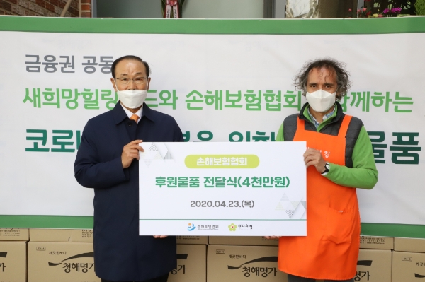 손해보험협회 김용덕 회장(왼쪽)이 안나의 집 김하종 신부에게 후원물품을 전달하고 있다. / 사진 = 손해보험협회