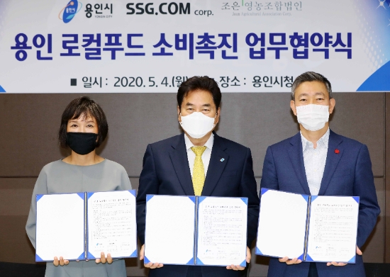 SSG닷컴과 용인시가 로컬푸드 소비촉진 업무협약(MOU)을 맺고 백군기 용인시장(가운데), 최택원 SSG닷컴 영업본부장 상무(가운데 오른쪽), 우미라 조은영농조합법인 대표(가운데 왼쪽)가 기념촬영하고 있다. / 사진 = 용인시