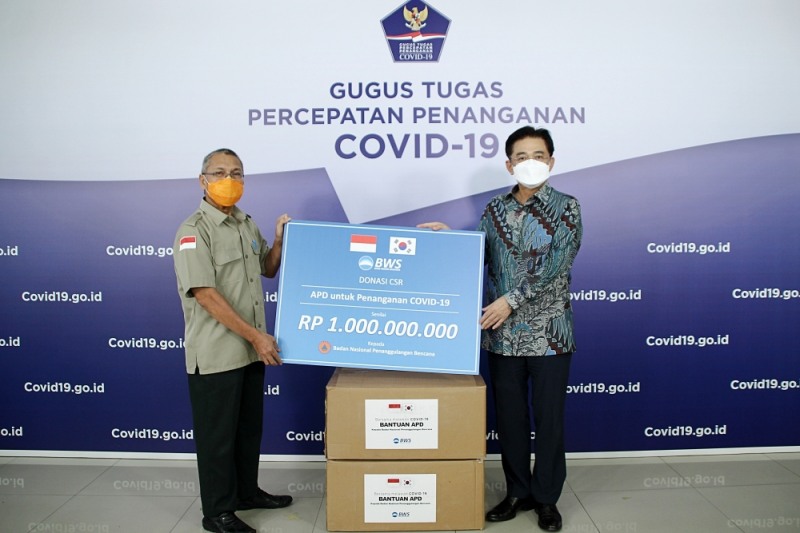 우리소다라은행은 인도네시아 자카르타의 국가재난방지청에 방호복 5000벌을 기부했다. 최정훈 우리소다라은행 법인장(사진 오른쪽)과 인도네시아 국가재난방지청 이브누(Ibnu)국장이 기념촬영을 하고 있다. / 사진= 우리은행(2020.05)