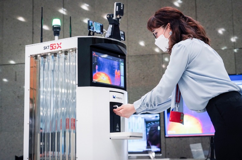 코로나19방역로봇이 방문객에게 손 소독제를 제공하고 있는 모습/사진=SK텔레콤