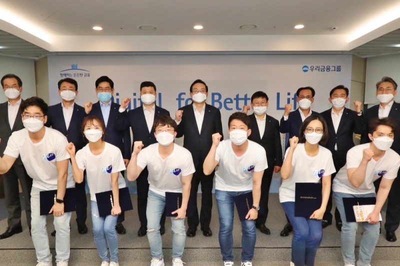 우리금융그룹은 지난 5월 15일 그룹 디지털 비전을 선포하고 '디지털혁신위원회' 출범식을 진행했다. 우리금융그룹 손태승 회장(뒷줄 왼쪽부터 다섯번째)과 권광석 우리은행장(뒷줄 왼쪽부터 네번째)이 자회사 CEO(최고경영자)로 구성된 디지털혁신위원회 위원 및 블루팀과 기념촬영을 하고 있다. (뒷줄 왼쪽부터) 이동연 우리에프아이에스 대표, 김종득 우리종합금융 대표, 정원재 우리카드 대표, 권광석 우리은행장, 손태승 우리금융그룹 회장, 이원덕 우리금융지주 전략부문 부사장, 김정기 우리금융지주 사업관리부문 부사장, 박경훈 우리금융지주 재무부문 부사장, 노진호 우리금융지주 IT/디지털부문 부사장 / 사진= 우리금융지주(2020.05.15)