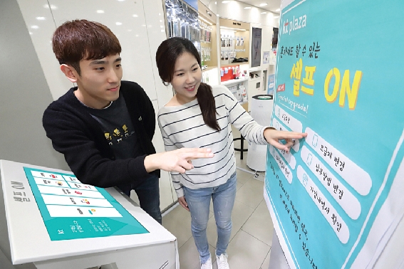 ▲ 모델들이 KT 대리점에서 무인 키오스크로 가입 및 요금납부 편리성 시연을 선보이고 있다. 사진 = KT