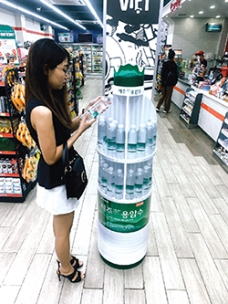 ▲ 베트남 현지 매장에서 한 여성이 오리온 제주용암수를 살피고 있다. 사진 = 오리온