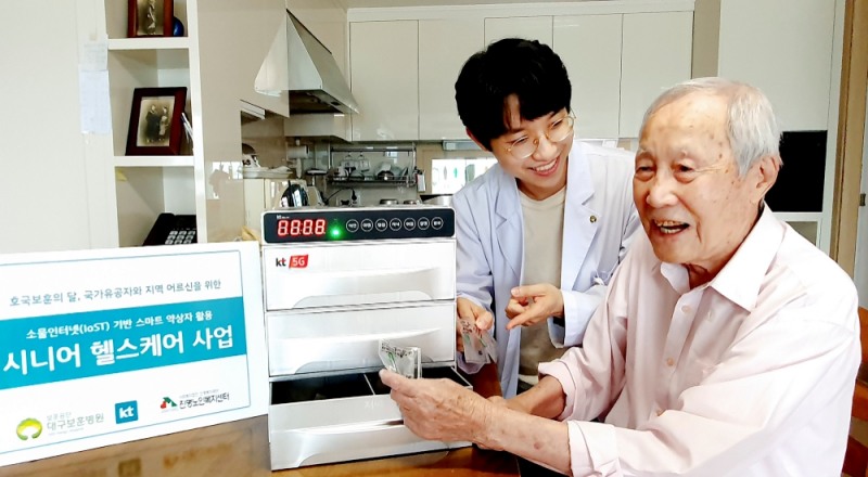 대구 보훈병원 방문간호사가 국가유공자 김갑생 씨의 자택에서 스마트 약상자를 이용해 복약 지도를 하고 있다/사진=KT