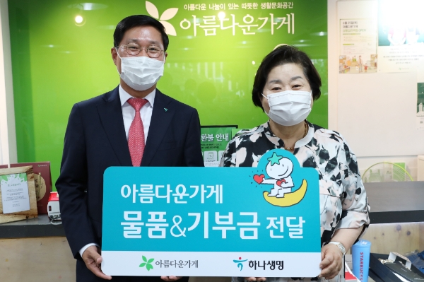 김인석 하나생명 대표는(왼쪽) 아름다운가게에서 지난 24일 열린 ‘하나생명과 함께하는 아름다운 특별전’에 기증품 1200여점과 함께 기부금을 전달했다. / 사진 = 하나생명