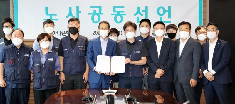 하나은행 노사는 2019년 임단협을 타결하고 전격적으로 신종 코로나바이러스 감염증(이하 코로나19) 극복 및 상생을 위한 노사 공동선언문을 발표했다. 30일 오전 을지로 하나은행 본점에서 지성규 은행장(사진 앞줄 왼쪽에서 네번째)과 최호걸 노조위원장(사진 앞줄 왼쪽에서 다섯번째)이 노사 공동선언문에 서명하고 참석한 노사 임직원들과 함께 기념촬영을 하고 있다. / 사진= 하나은행(2020.06.30)