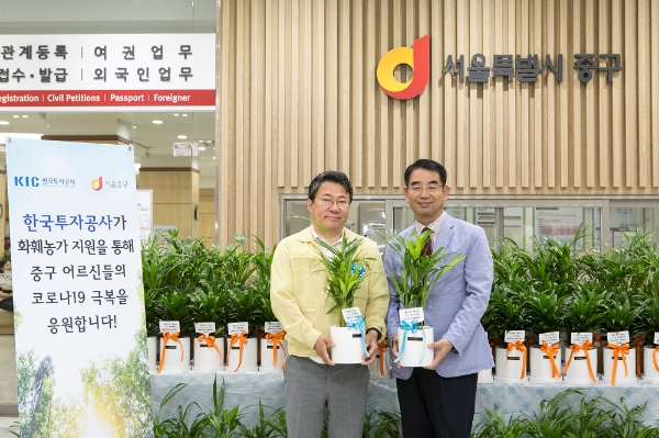 ▲최희남 KIC 사장(오른쪽)이 17일 서울 중구청에서 열린 ‘플라워 버킷 챌린지’ 캠페인 행사에서 서양호 중구청장에게 화분을 전달하고 기념촬영을 하고 있다./ 사진=한국투자공사